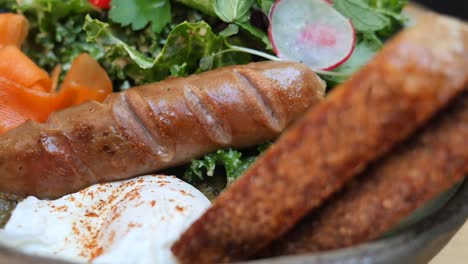hearty breakfast bowl with sausage, eggs, and vegetables