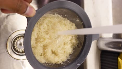 washing rice in a colander