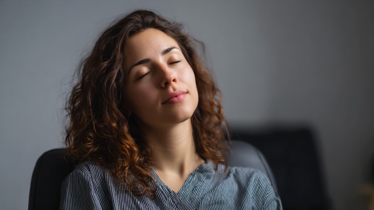 Una giovane donna con i capelli ricci sperimenta un profondo relax e tranquillità, con gli occhi chiusi e un'espressione serena, mostrando un momento di calma interiore e consapevolezza