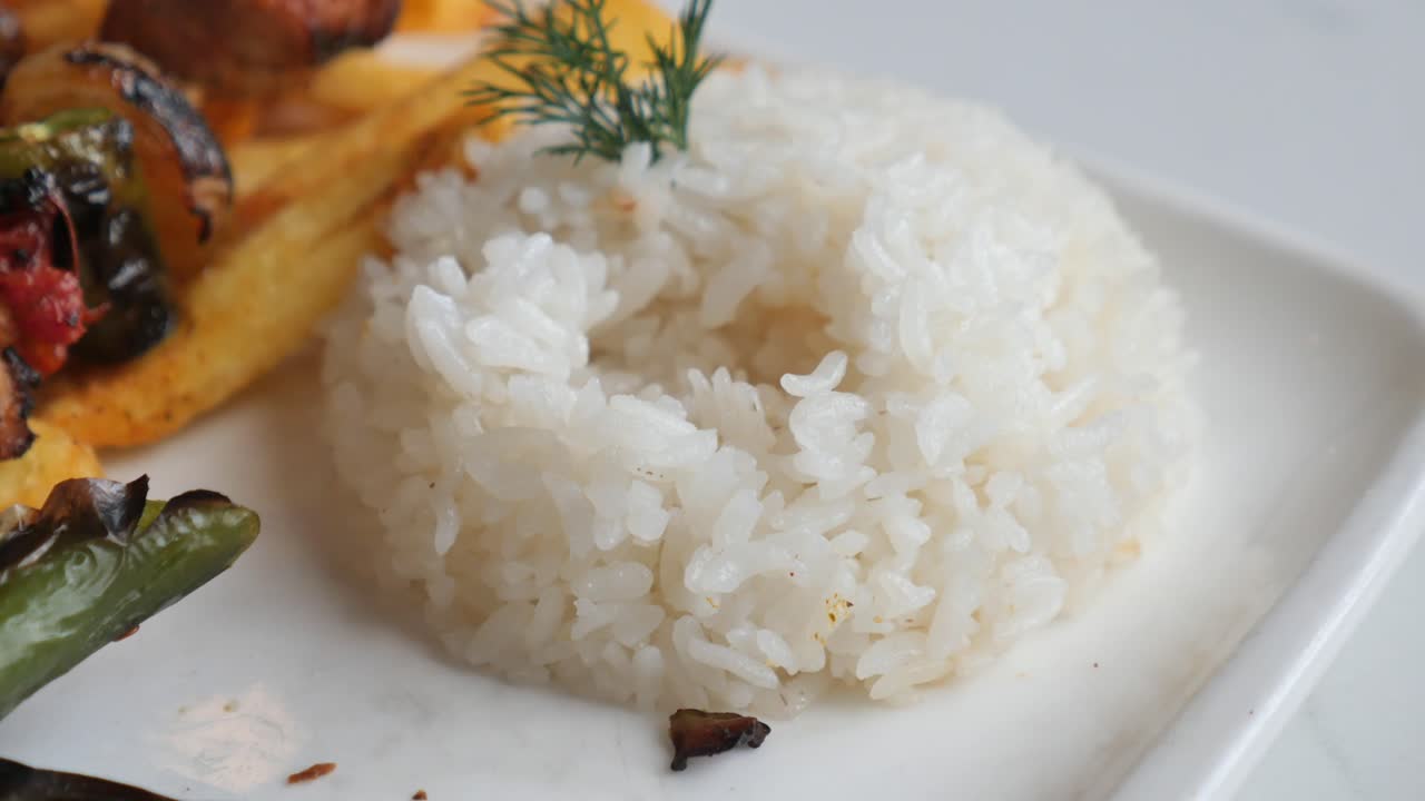 Close-up of Fork Picking Up White Rice from a Plate