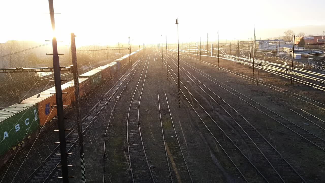 Aerial view of a passing train. Winter sunset during the rain. Cinematic shot.