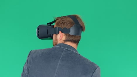 joven usando gafas modernas de realidad virtual en un fondo de pantalla verde, 4k