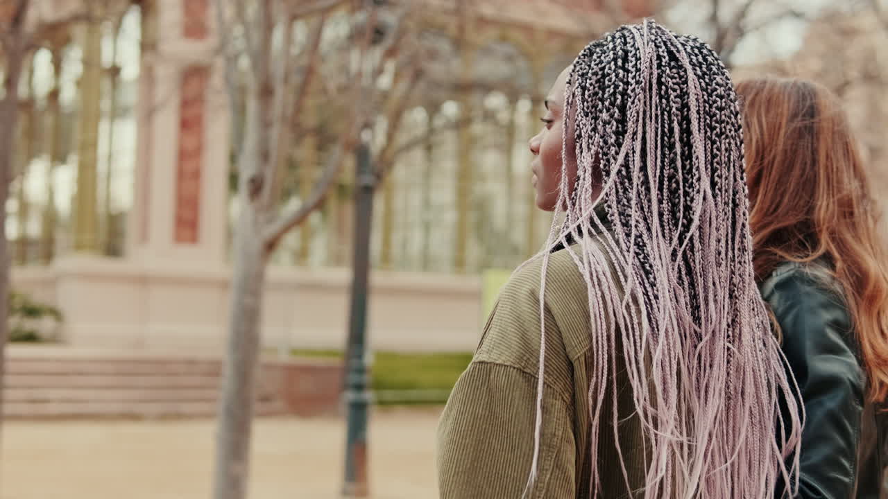 Back View of Young Woman with Braids Standing in a Park