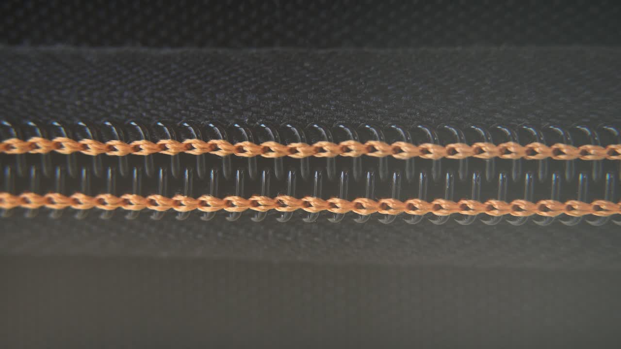 단단한 케이스 지퍼가 천천히 열리는 매크로 클로즈업, 오렌지색 노란색, 금속 지퍼, 블랙 박스, 사진 장비, 전문 스튜디오 조명, 정적 4k 비디오