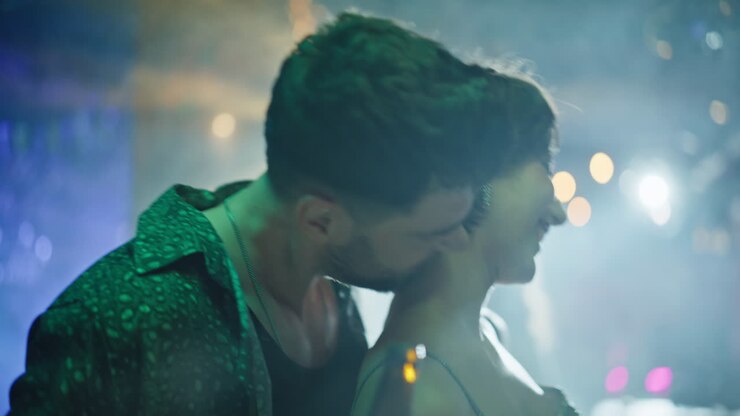 Primo piano di coppia sorridente che balla in discoteca. Uomo felice che flirta con una donna