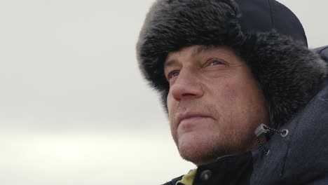 Close-up-of-male-face-looking-around-in-windy-and-cold-Icelandic-landscape