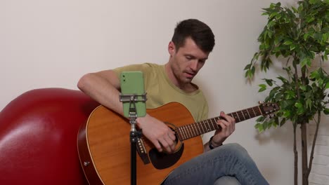 man playing acoustic guitar, live streaming music lesson