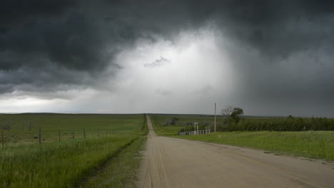 quiet road leading away with storm clouds and rain spinning over head