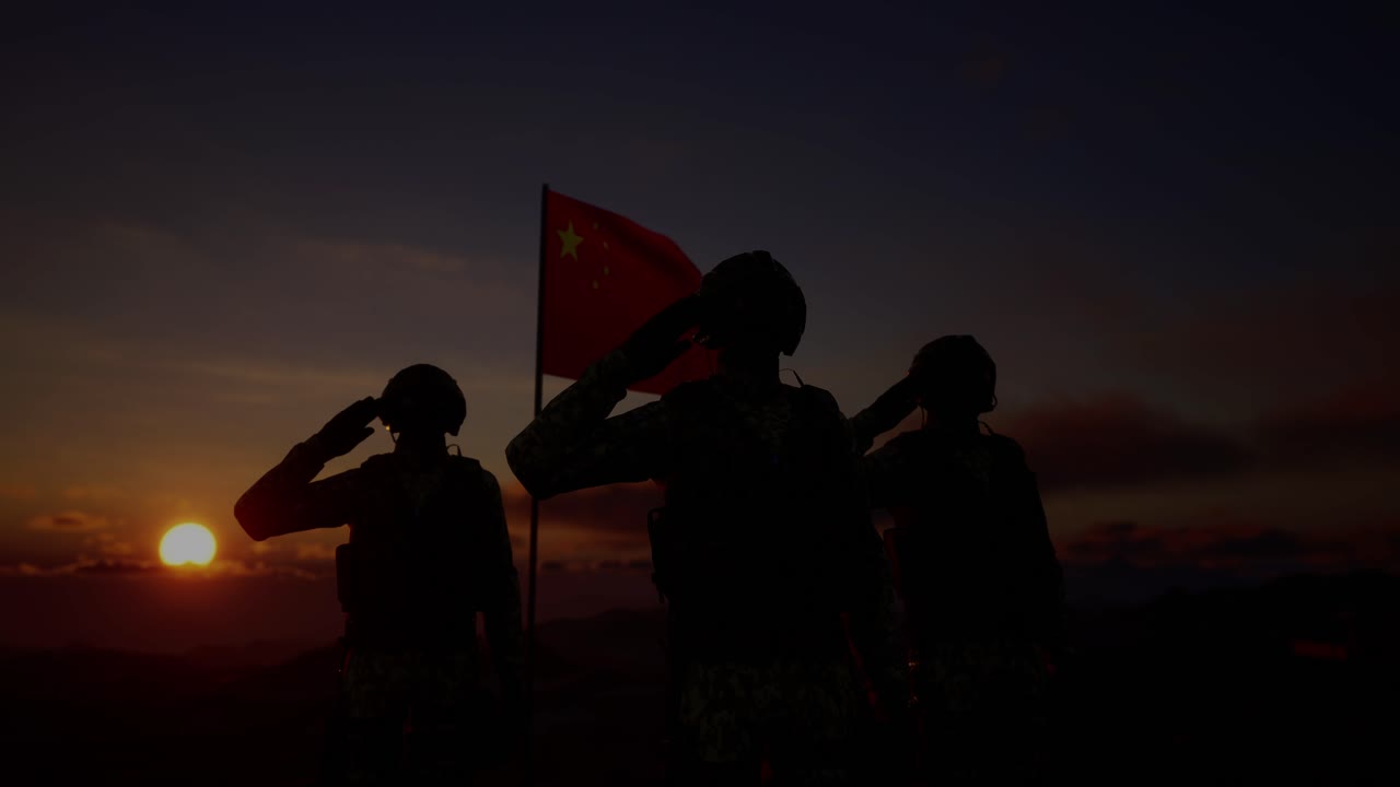 중국 발을 들고 있는 군인의 실루은 해가 지거나 해가 뜨는 배경에 서 있습니다.