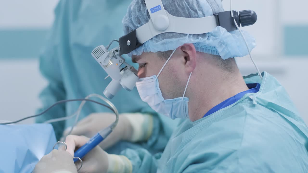 operación de extirpación de amígdalas. amigdalectomía bajo anestesia profunda, utilizando los últimos dispositivos, método de plasma frío, cortes hinchazón en la garganta, el médico trabaja con una nueva sonda, lámpara frontal médica, lupas quirúrgicas