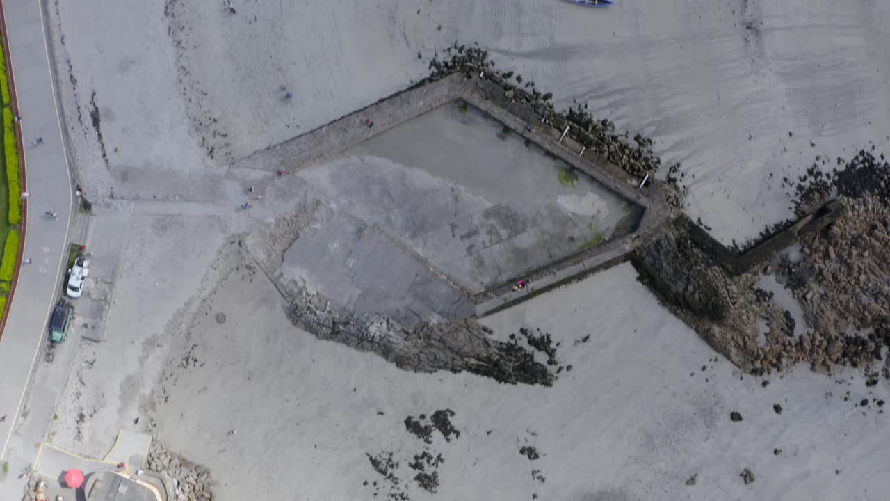 Top down aerial bird's eye view above tidepools at ladies beach galway, and currach boats
