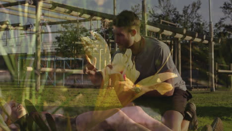 man helping another person on ground overlaid with yellow flower animation