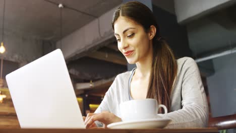 mujer usando una computadora portátil en un café 4k