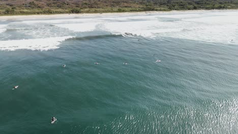 aerial view of a crowded beach full of surfers in nosara, costa rica