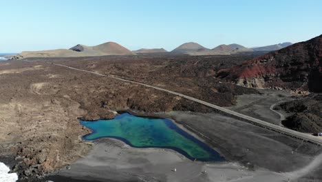 Drohnenrotationen-Auf-Einem-Kleinen-See,-Die-Das-Vulkanland-Von-Lanzarote-Und-Das-Küstenpanorama-Freigeben