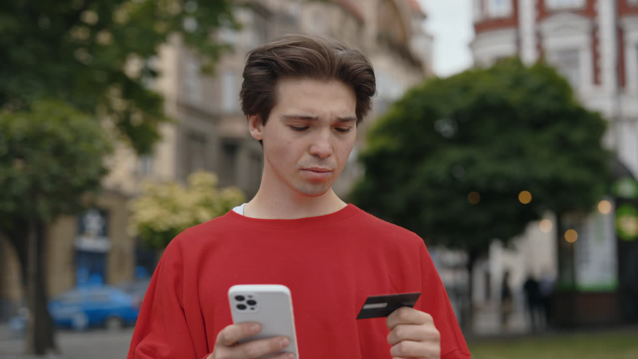 Man using mobile phone and credit card on the street