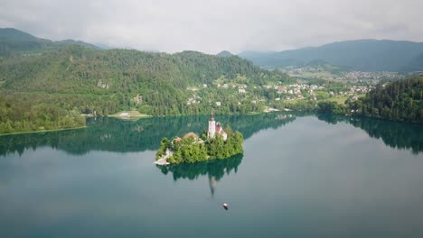 aerial view pulling away from the assumption of maria church in the middle of slovenia's lake bled