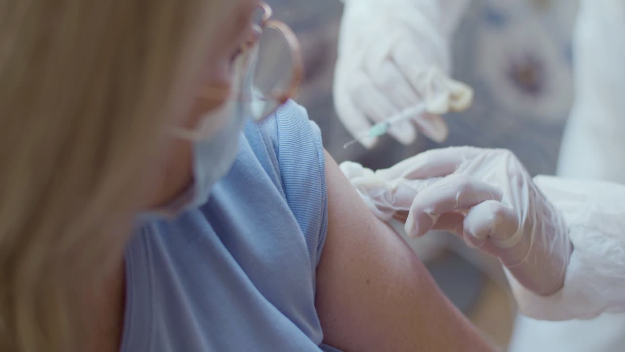 Primo piano delle mani del medico che vaccina una donna contro il covid.
