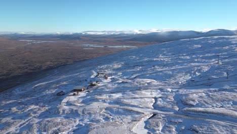 Snowy-Glencoe-landscape-with-mountain-peaks-and-clear-blue-sky,-aerial-view