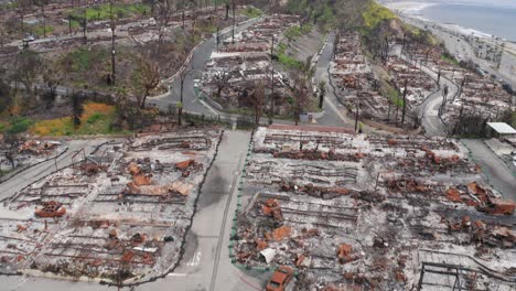bird's eye aerial shot flying over an oceanfront gated community destroyed by the palisades fire in pacific palisades, california. 4k