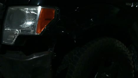 police light flashing on a damaged pickup truck wheel well after a wreck