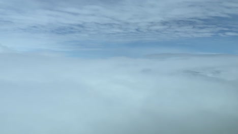 cockpit view overflying a sea of white clouds