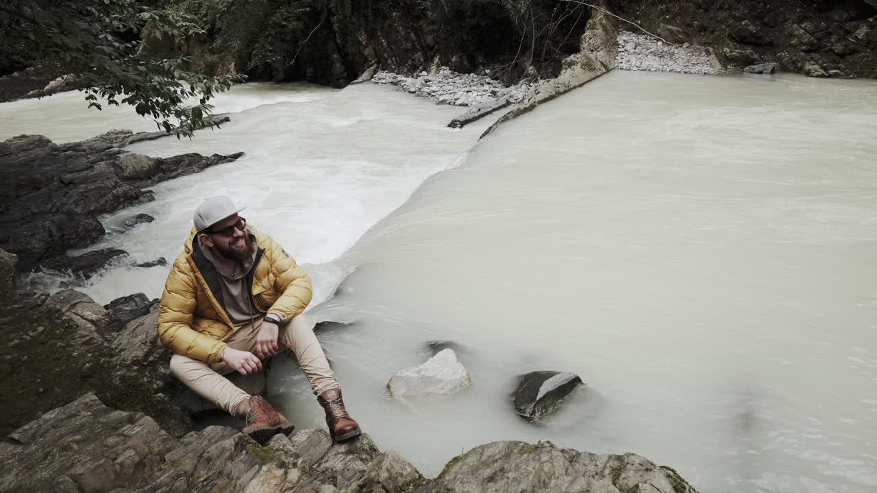 hombre disfrutando de una vista de cascada en un entorno forestal sereno