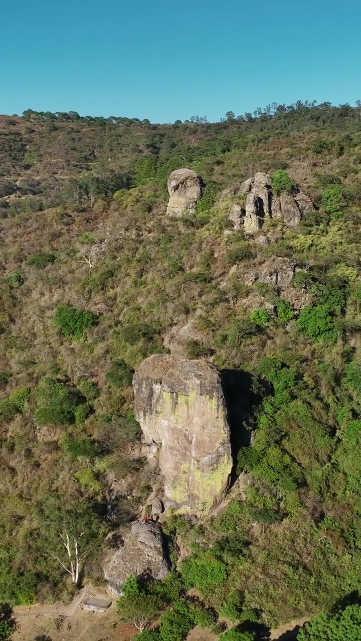 Cảnh quay flycam kéo lùi từ trên cao theo chiều dọc của El Nido del Zopilote và Piedrotas Los Compadres trong Công viên Sinh thái Las Peñas, Ciudad Guzman, Mexico