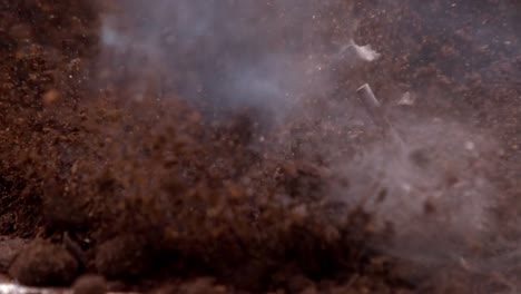 firecracker under soil against black background