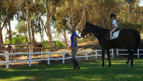 Mother-assisting-daughter-during-horse-riding-4k