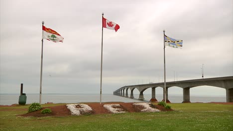 a wide shot of 3 flags with pei written in the red earth below