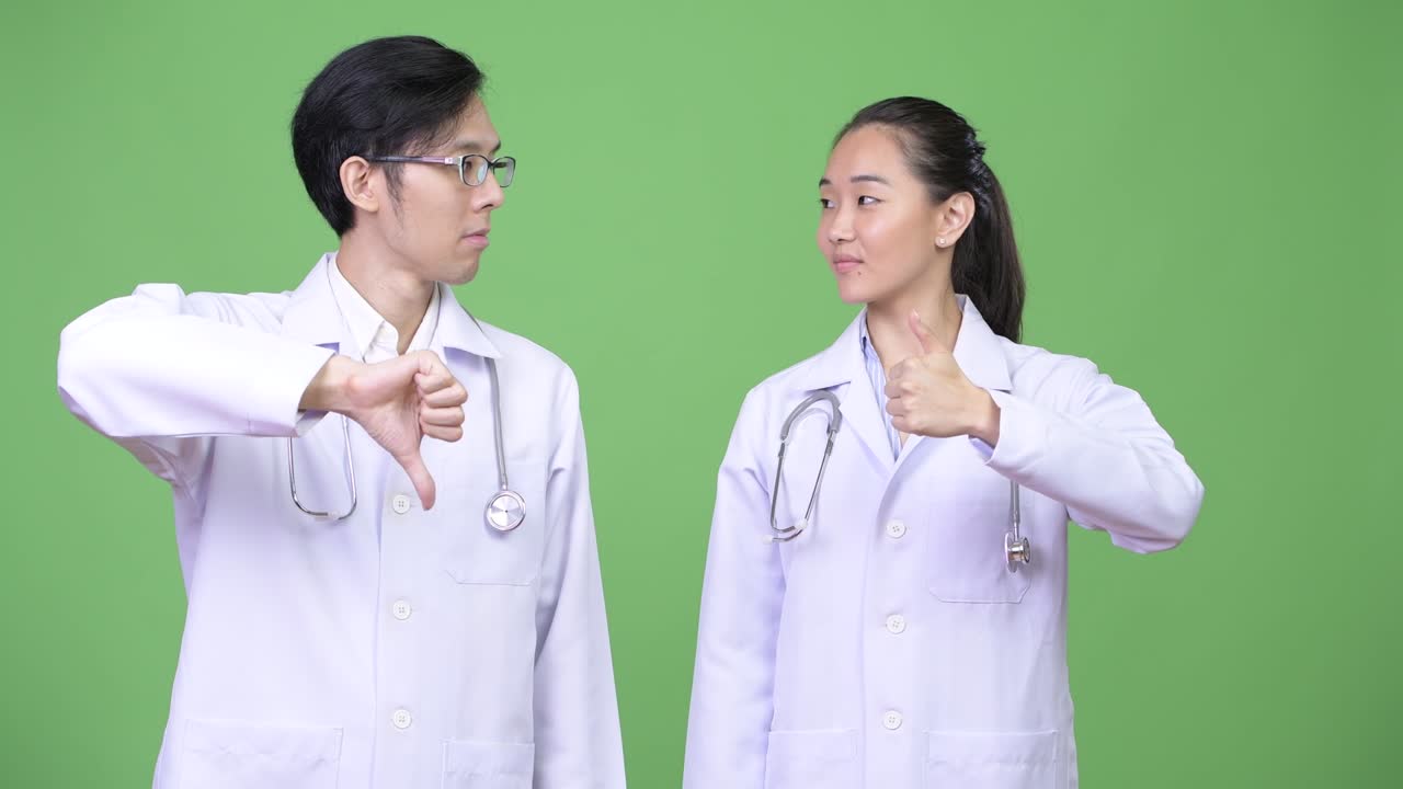 Young Asian couple doctors having different decisions together