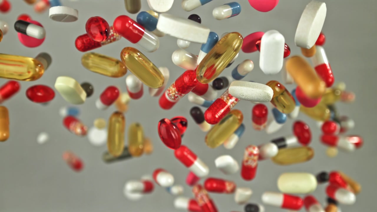 Colorful Pills and Capsules Falling in Slow Motion