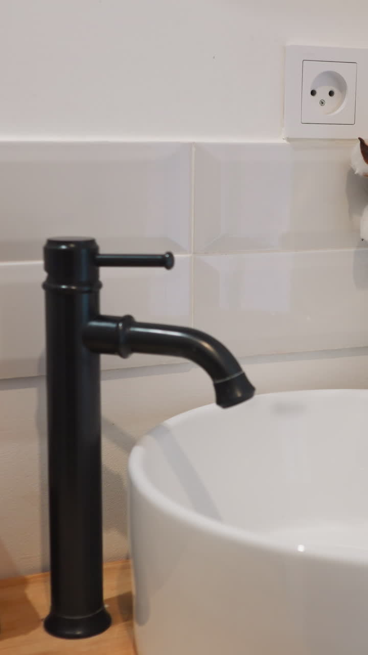 fregadero de cerámica con grifo en el baño del hotel. lugar para mantener las manos limpias y elementos decorativos para mejorar la apariencia del apartamento. procedimientos de higiene en vacaciones