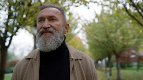 retrato de un hombre maduro con larga barba gris al aire libre.