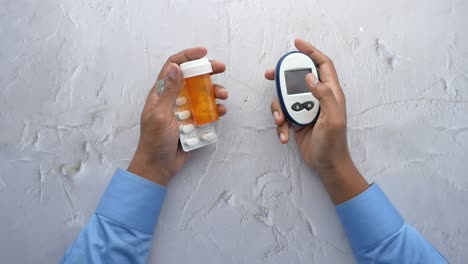 Men-holding-a-glucose-meter-and-medical-pills-,