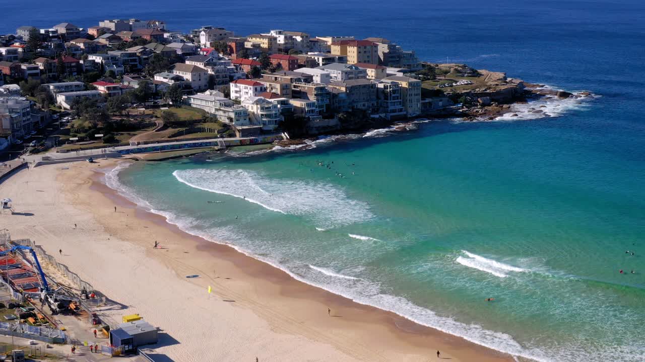 varias personas en la playa de bondi durante el día con vistas a ben buckler point en los suburbios de sydney, nueva gales del sur, australia
