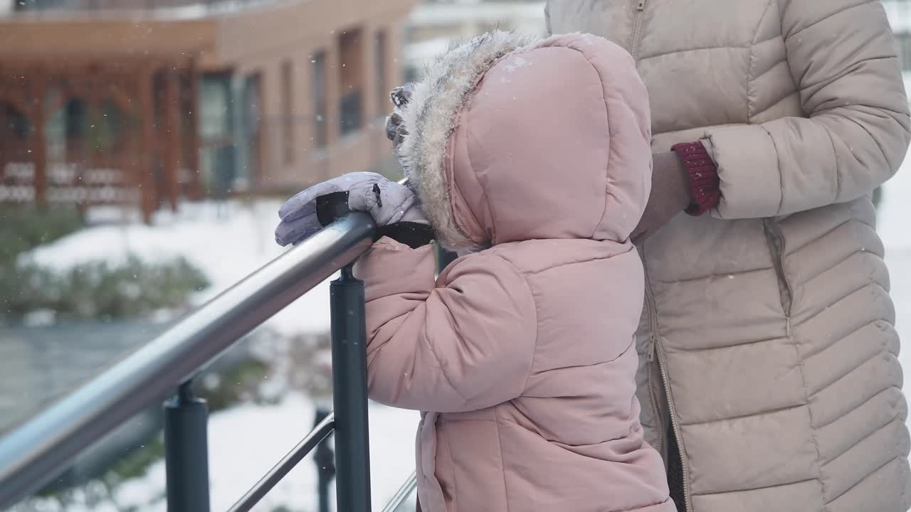 Little Girl and Mother Enjoying Snowy Day