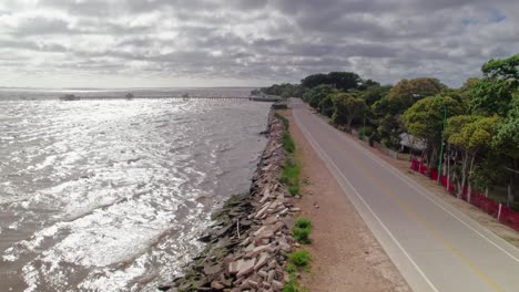 aerial view of the shoreline in punta lara, buenos aires, showcasing the riverfront road and rocky edges.