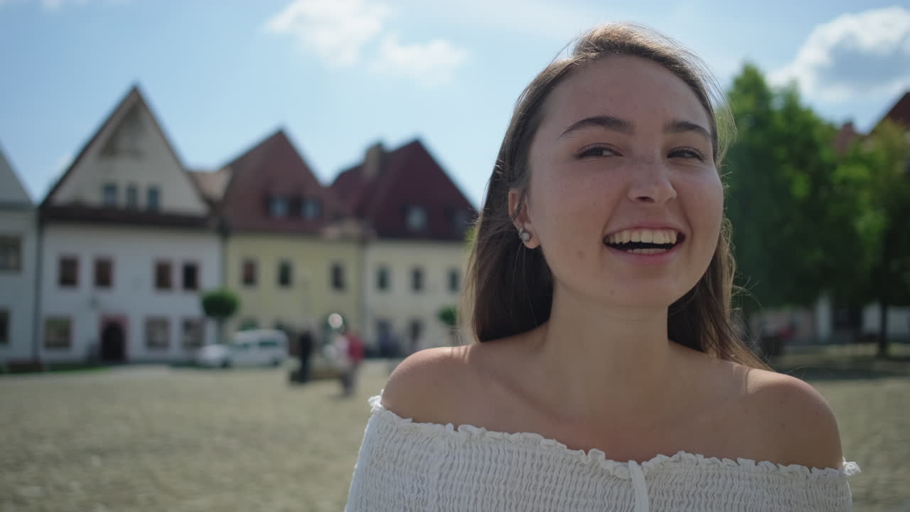 유럽 마을에서 미소 짓는 젊은 여성