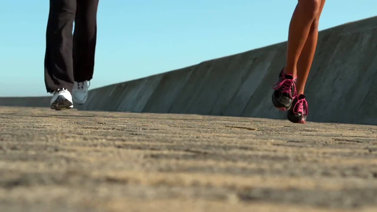 Two sporty women jogging together