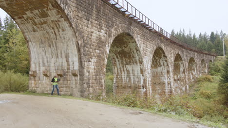 old stone train bridge with maintenance worker