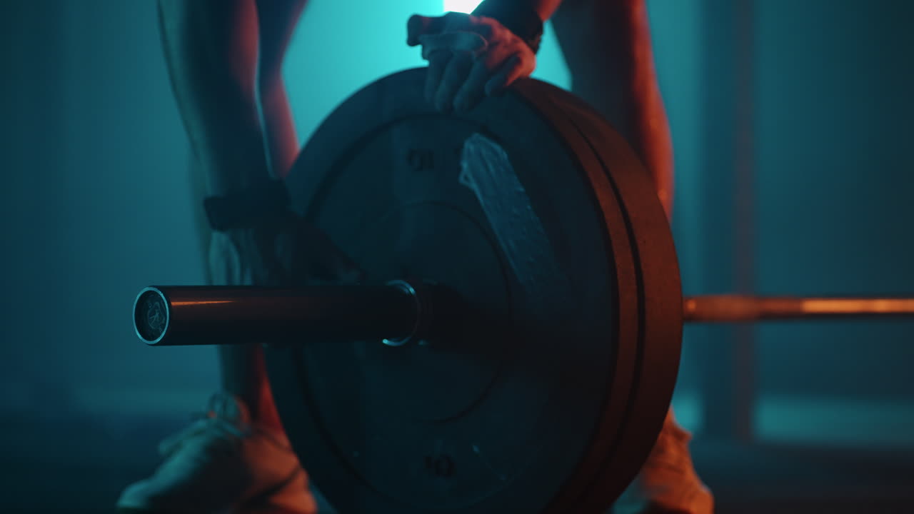 el deportista está instalando pesas en la barra para entrenar en el gimnasio el levantador de pesas está ajustando el equipo