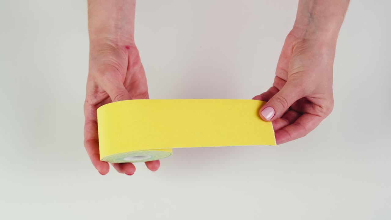 Kinesiology medical taping, doctor Physical therapist applying elastic surgical tape to patient body, treating injured knee young athlete.Post traumatic rehabilitation, sport physical therapy recovery