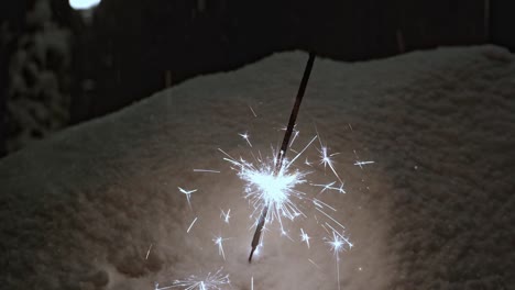 the flame of a sparkler stuck in the snow