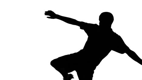 Silhouette-of-soccer-player-kicking-ball-