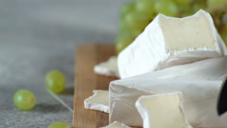 pieces of camembert cheese on cutting board slowly rotate.