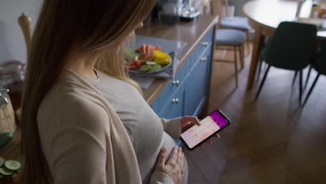 pregnant woman using mobile app on smartphone.