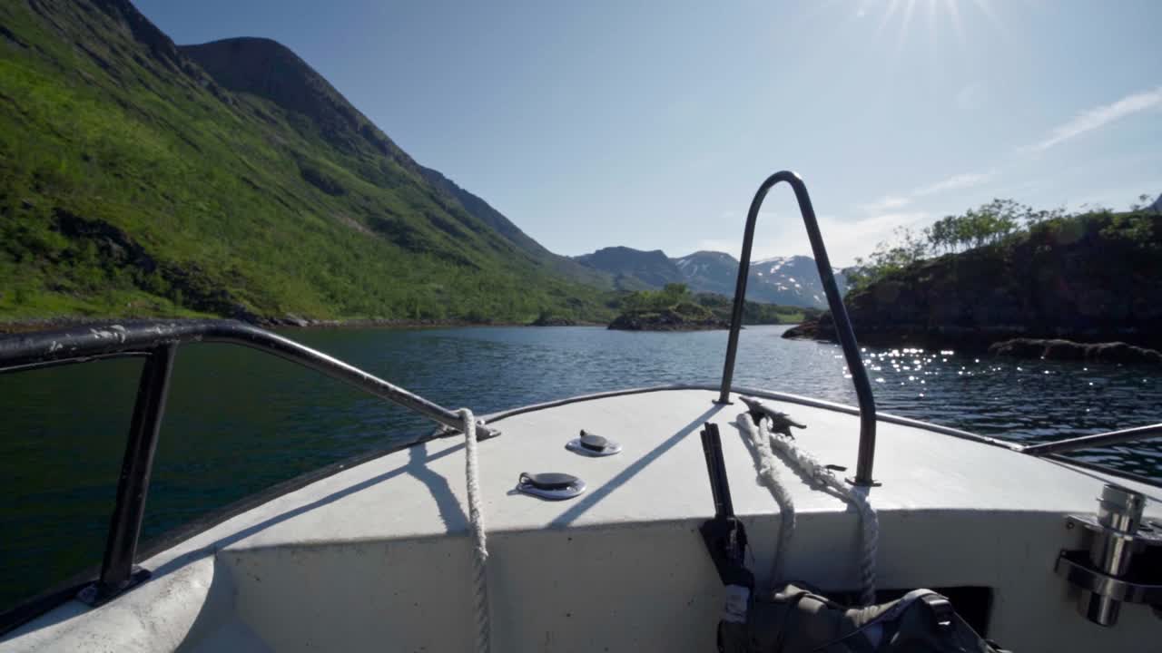 barco navegando bajo un cielo soleado con un paisaje de crestas al fondo en noruega