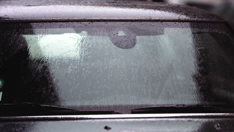 super imágenes en cámara lenta de gotas de lluvia golpeando el parabrisas de un coche